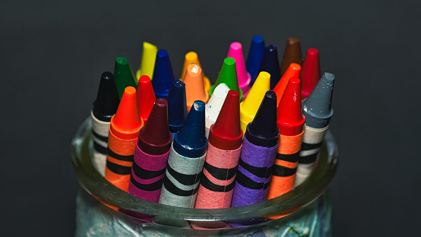 Zdjęcie przedstawia wstawione do słoika świecowe kredki. 