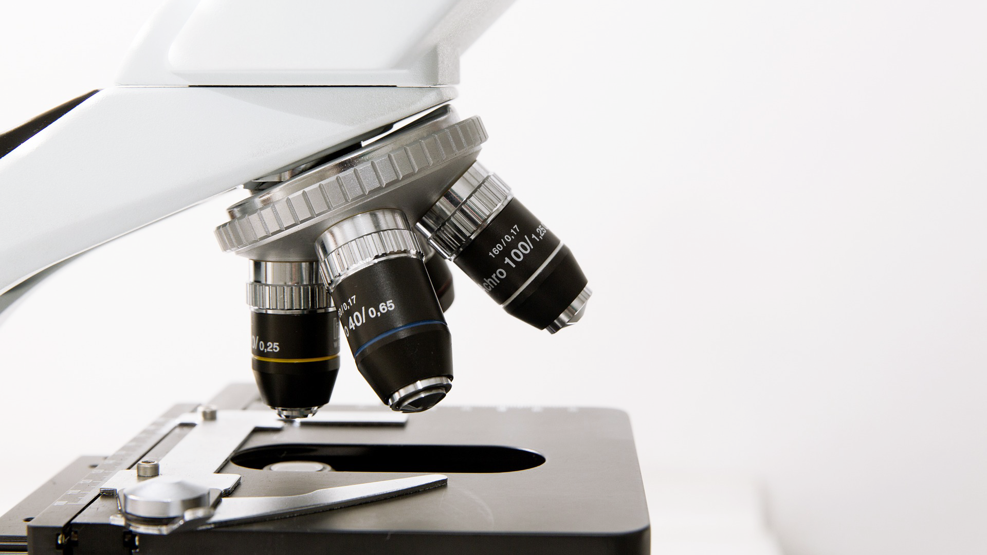 Zdjęcie przedstawia zbliżenie na obiektywy i stolik mikroskopu optycznego.
