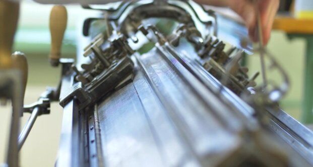 Zdjęcie przedstawia zbliżenie na kompensator. Widoczna jest metalowa obudowa, pokrętła i drewniane rączki.