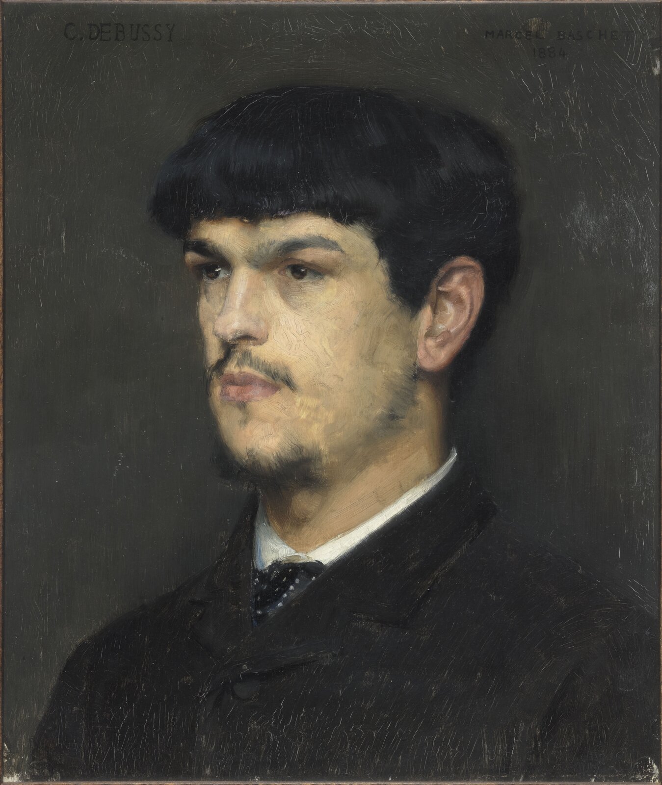 
Portret Claude'a Debussy'ego namalaowany przez Marcela Bascheta w 1884 r.
Postać na obrazie jest młodym mężczyzną z czarnymi, krótkimi, gęstymi włosami i zarostem, ubranym w czarny płaszcz, pod którym widać białą koszulę z krawatem.