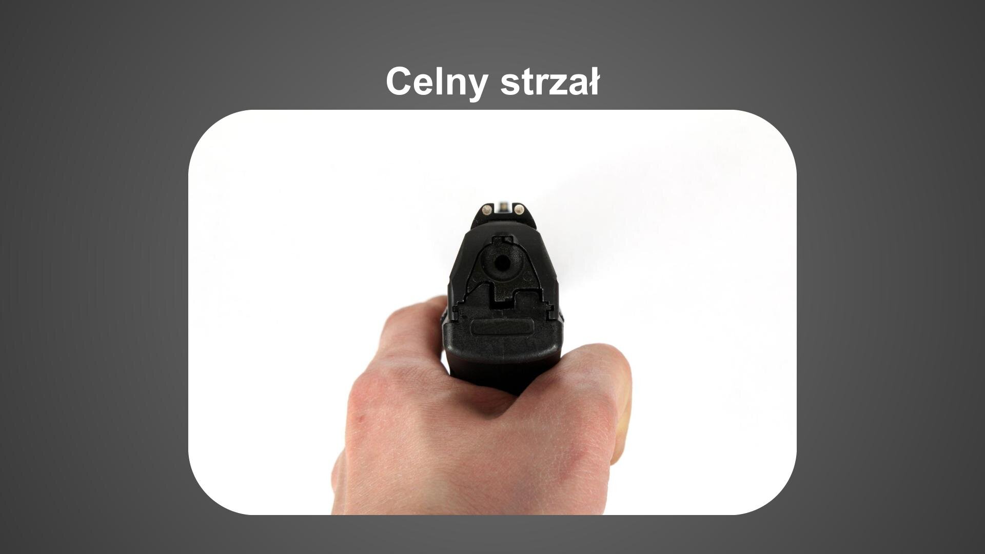 Szara plansza. U góry biały napis: „Celny strzał”. Poniżej zdjęcie dłoni, która trzyma pistolet. Tło białe.