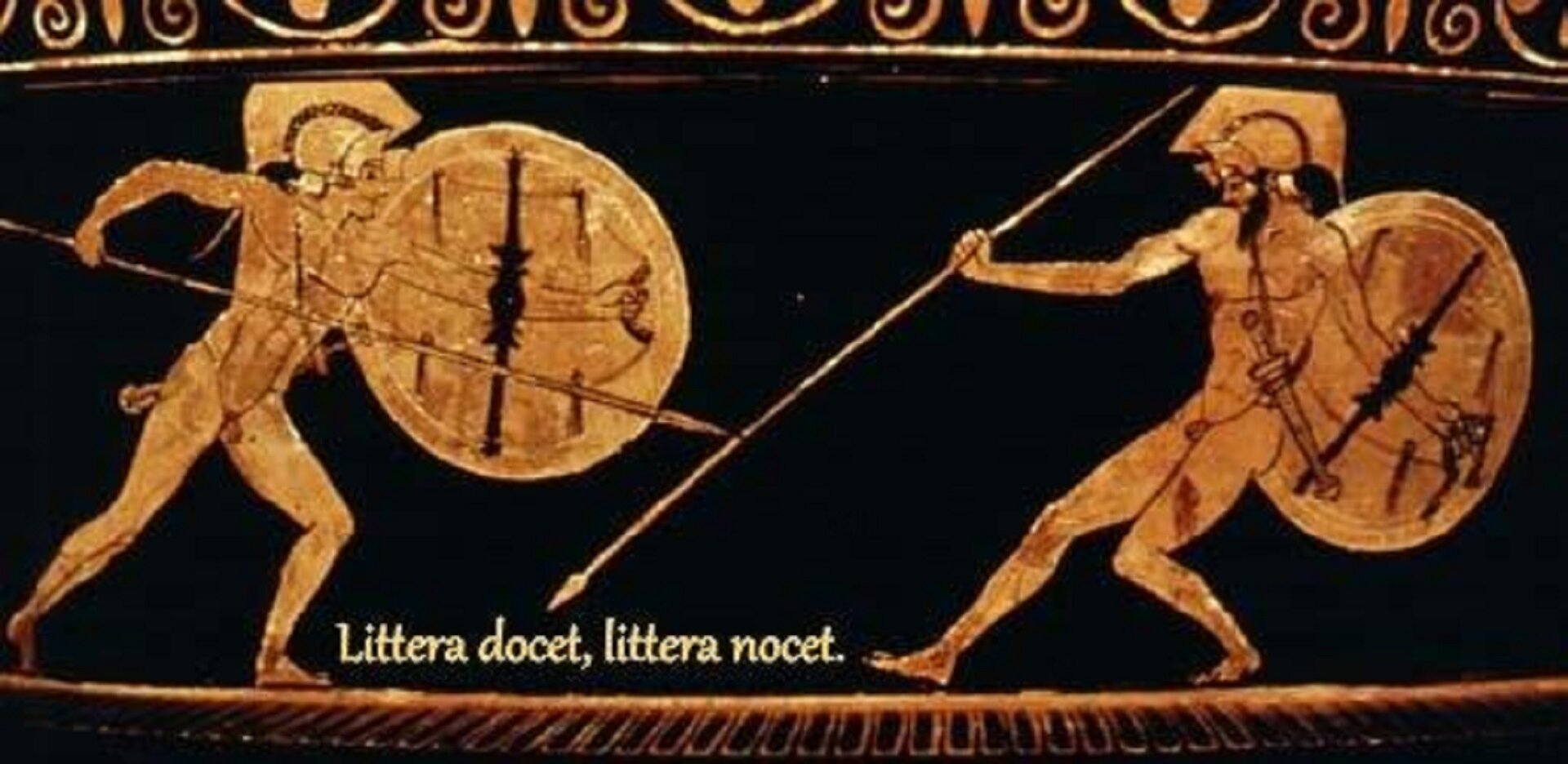 Fotografia nieznanego autora przedstawia malarstwo czerownofigurowe na bliżej nieokreślonym naczyniu, na którym znajdują się dwie walczące postacie – Achilles i Hektor. Achilles znajduje się po lewej stronie, jest nagi, w jednej dłoni trzyma tarczę, a w drugiej włócznię. Jego przeciwnik również jest nagi, w jednej dłoni trzyma tarczę, w drugiej włócznię. Na pasie ma przewieszony miecz. Pod sceną walki widnieje napis: Littera docet, littera nocet.