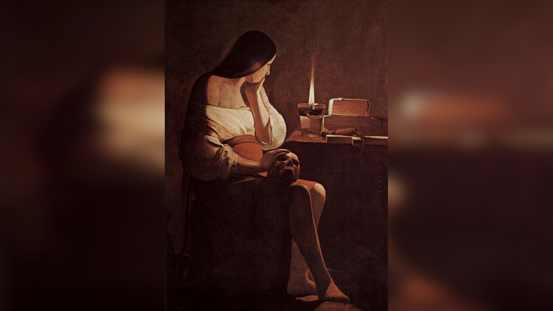 Obraz przedstawia młodą kobietę, która siedzi przy stoliku. Ma czerwoną spódnicę i białą bluzkę. Na kolanach trzyma ludzką czaszkę, dotyka jej prawą dłonią. Lewą ręką opiera głowę. Ma długie, ciemne włosy. Patrzy na płonącą świecę, która stoi na stoliku. Obok leżą pudełka i sznur. Wokół panuje ciemność, świeca jest jedynym źródłem światła.