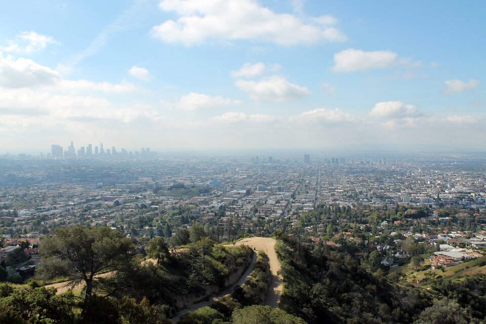 Na ilustracji ukazano widok na Los Angeles. Na wysokości wieżowców znajduje się warstwa smogu. Powyżej niebo jest niebieskie, przysłonięte białymi chmurami.