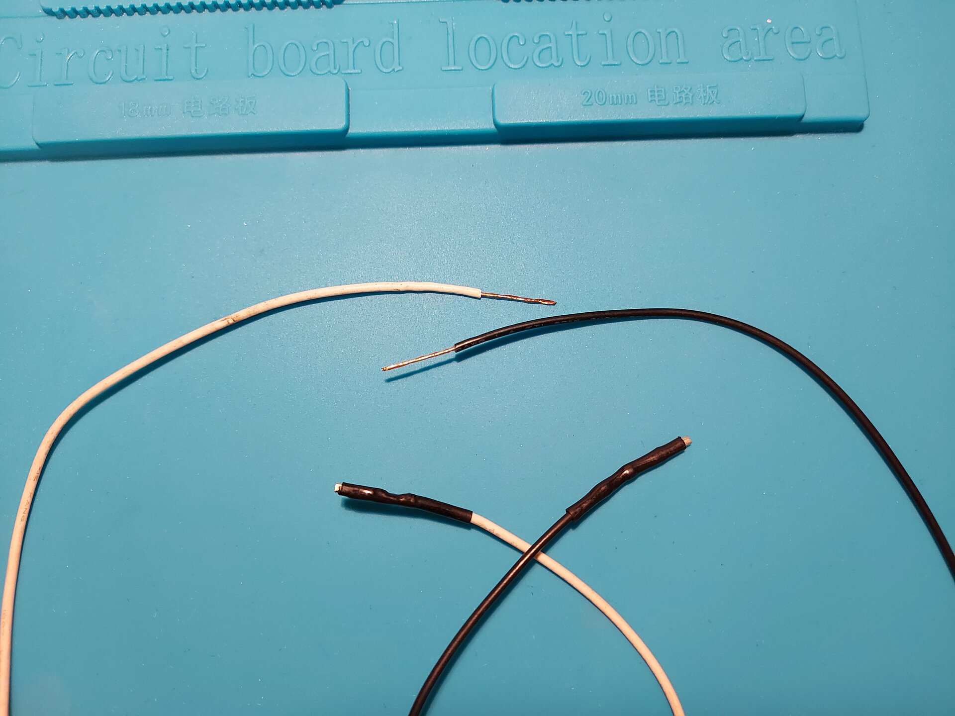 Zdjęcie przedstawia 4 przewody, 2 z taśmą izolacyjną na końcach, 2 z usuniętą izolacją tym samym odsłaniając miedziane wnętrze.