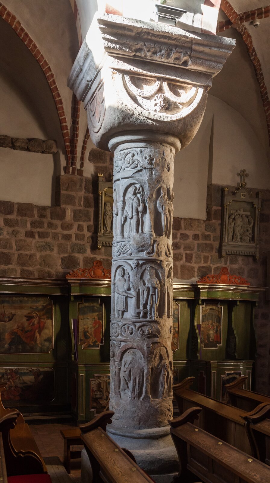 Ilustracja o kształcie poziomego prostokąta przedstawia fotografię kolumny św. Trójcy w Strzelnie. Ukazuje alegorie słabości ludzkich, ułożone pasami jedne nad drugimi, oddzielone ornamentem w postaci wici roślinnej. Kolumnę wieńczy kostkowa głowica.