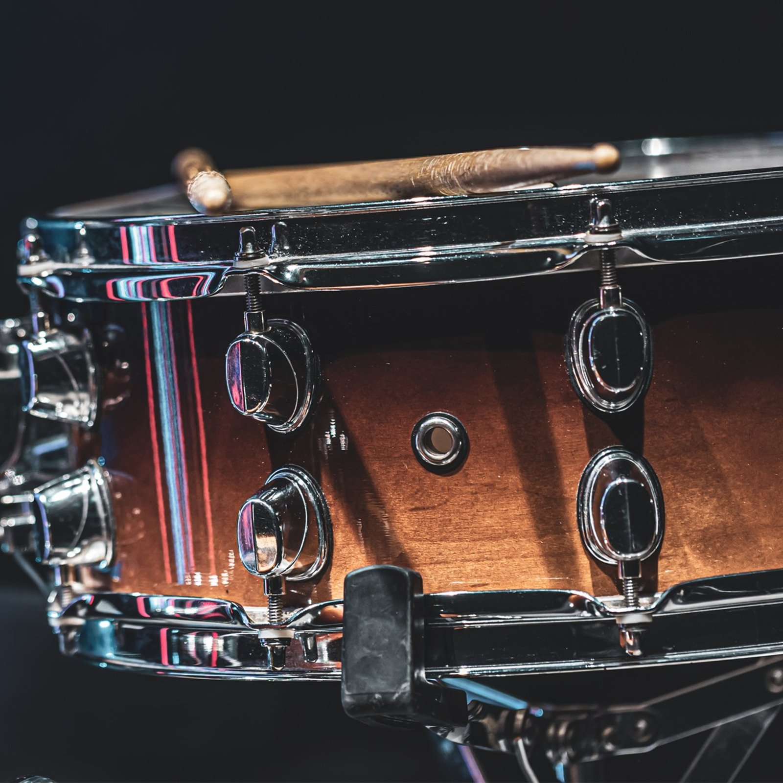 Ilustracja przedstawia werbel z pałeczkami na wierzchu.