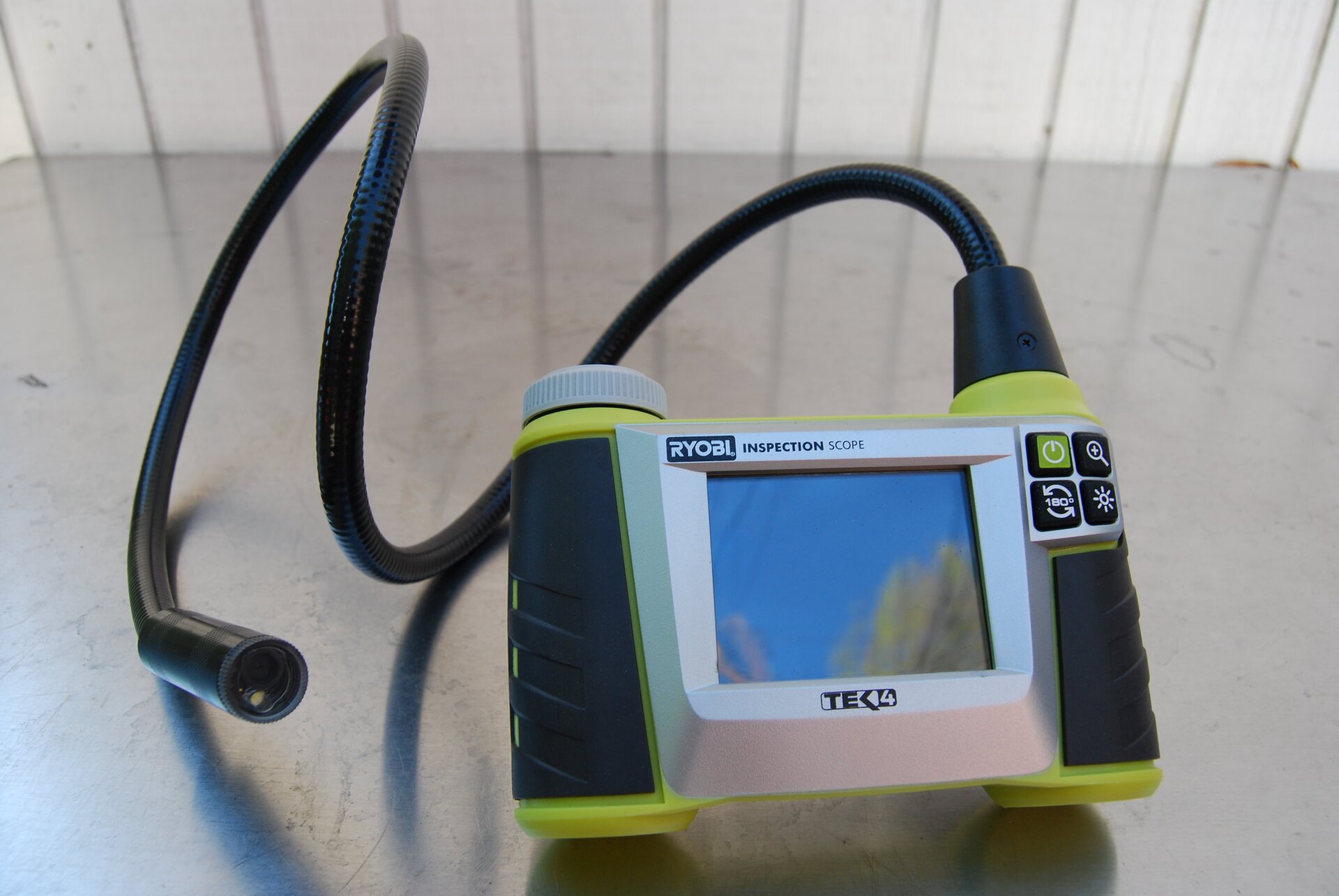 Zdjęcie przedstawia urządzenie służące do oceny wnętrza przewodów, rur oraz kominów. Korpus przyrządu posiada dwa uchwyty boczne zintegrowane, pośrodku znajduje się monitor. Na jednym z uchwytów widoczne są przyciski sterujące. Do urządzenia podłączony jest przewód kamery, na końcu którego znajduje się obiektyw.