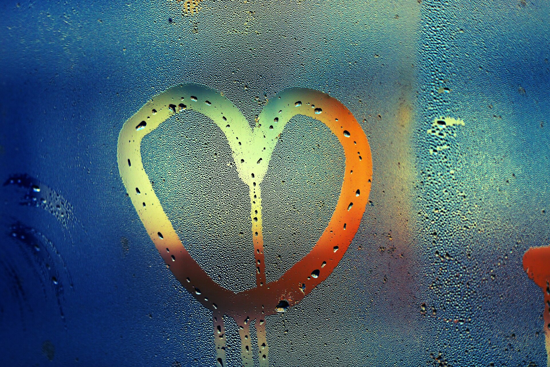 Rys. 6. Zdjęcie poglądowe przedstawia  „zaparowaną” szybę, na której skropliła się para wodna zawarta w powietrzu. Na szybie ktoś narysował palcem kształt serca.