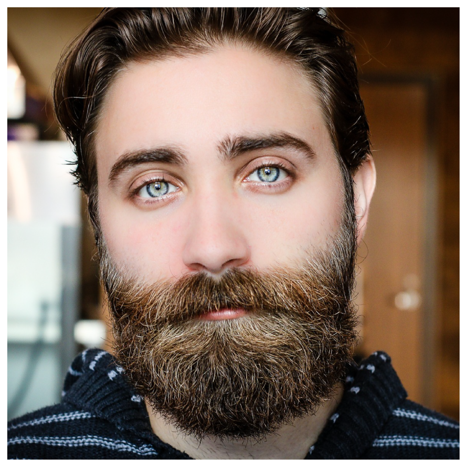 Ilustracja przedstawia młodego mężczyznę o brązowych włosach i z brodą.