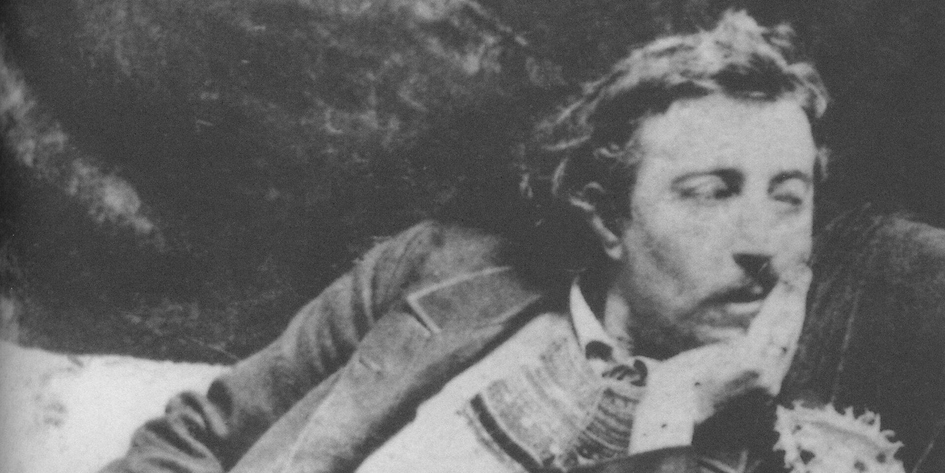 Ilustracja przedstawia czarno-białe zdjęcie Paula Gauguina. Ukazuje popiersie mężczyzny z wąsami, trzymającego głowę na lewej dłoni. Ma długie włosy zaczesane do tyłu. Ubrany jest w koszulę i marynarkę.