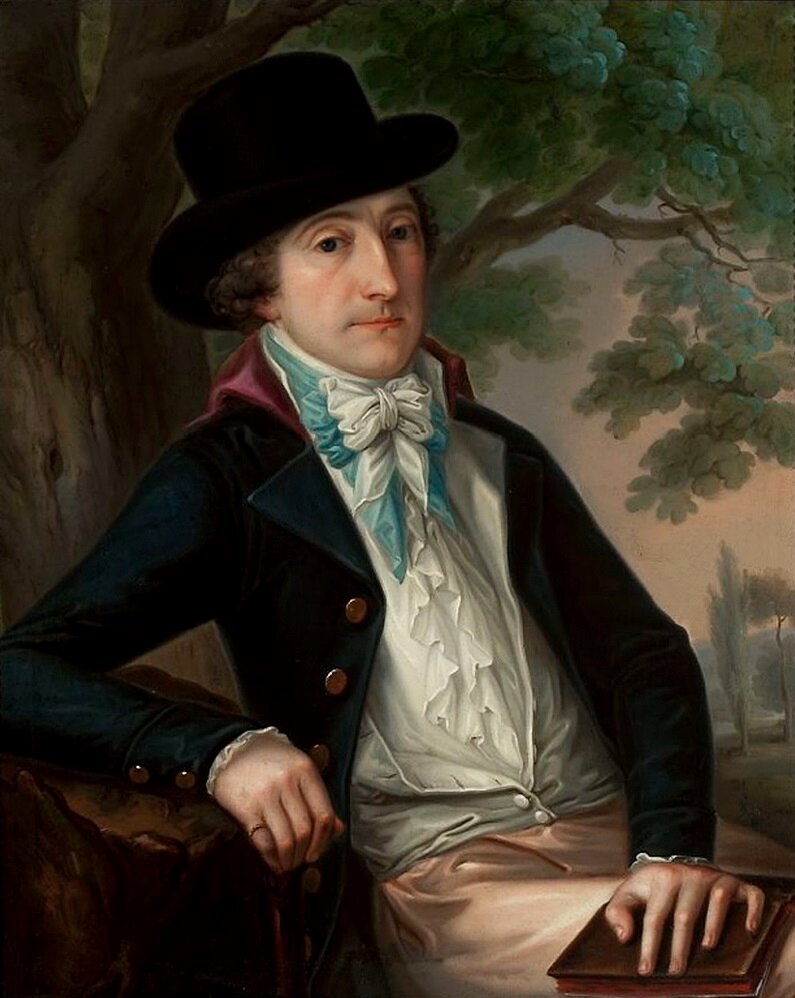 Obraz przedstawia portret mężczyzny w średnim wieku, siedzącego pod drzewem. Mężczyzna ubrany jest w ciemną kamizelkę, białą koszulę oraz wiązaną w kokardę chustę pod szyją. Na głowie ma kapelusz. Na kolanach, pod dłonią trzyma książkę.