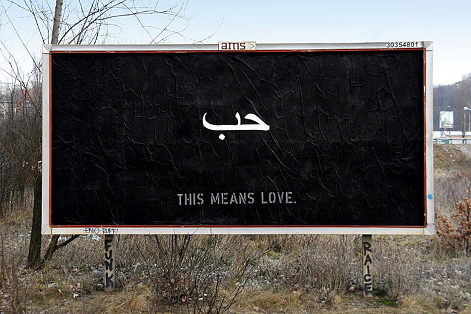 Billboard przedstawiający na czarnym tle biały napis This means love. 