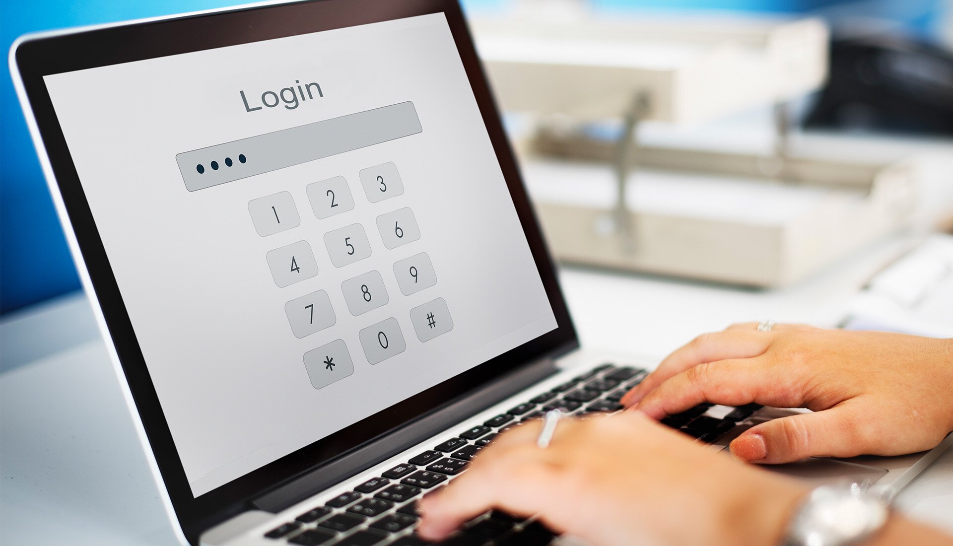 Zdjęcie przedstawia laptop, na którego ekranie widoczny jest napis: LOGIN. Pod napisem widoczne jest pole, w którym ktoś wpisuje hasło.