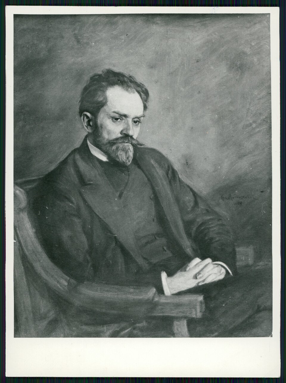 Obraz przedstawia czarno‑biały portret Stefana Żeromskiego. Mężczyzna ma łysinę z przodu i brodę. Jest ubrany w koszulę, kamizelkę i surdut. Ręce ma splecione z przodu. Siedzi w fotelu. Ma założoną nogę na nogę. Jego twarz wyraża powagę. Portret jest umieszczony na białym tle. Obraz otacza czarna cienka rama.