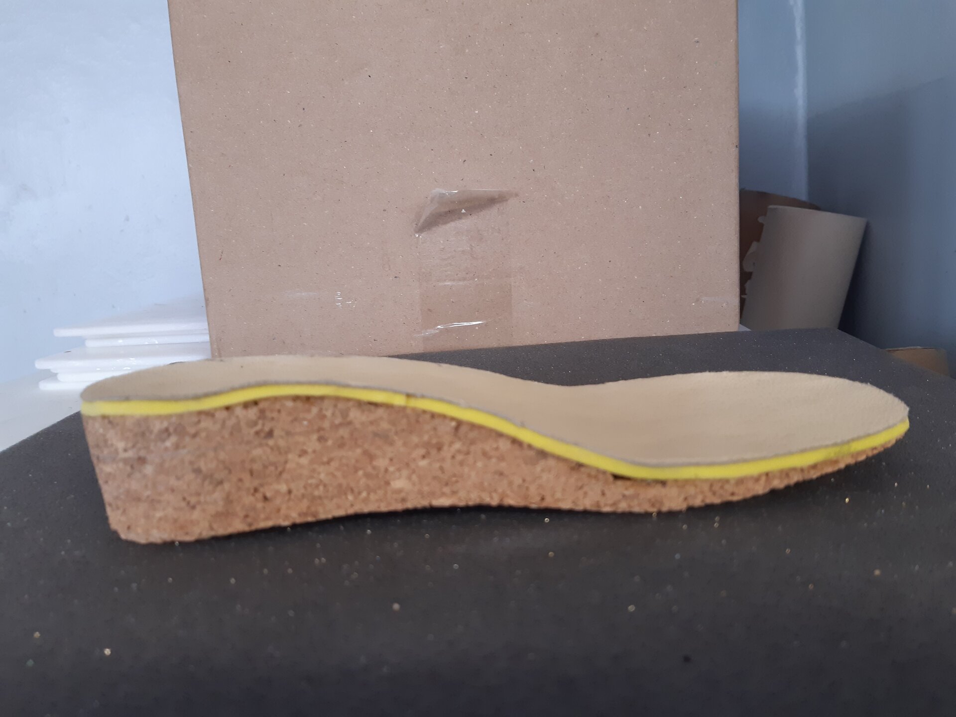 Zdjęcie przedstawia model wkładki wyrównującej, z podwyższeniem w części piętowej stopy, obniżającym się ku przodowi.