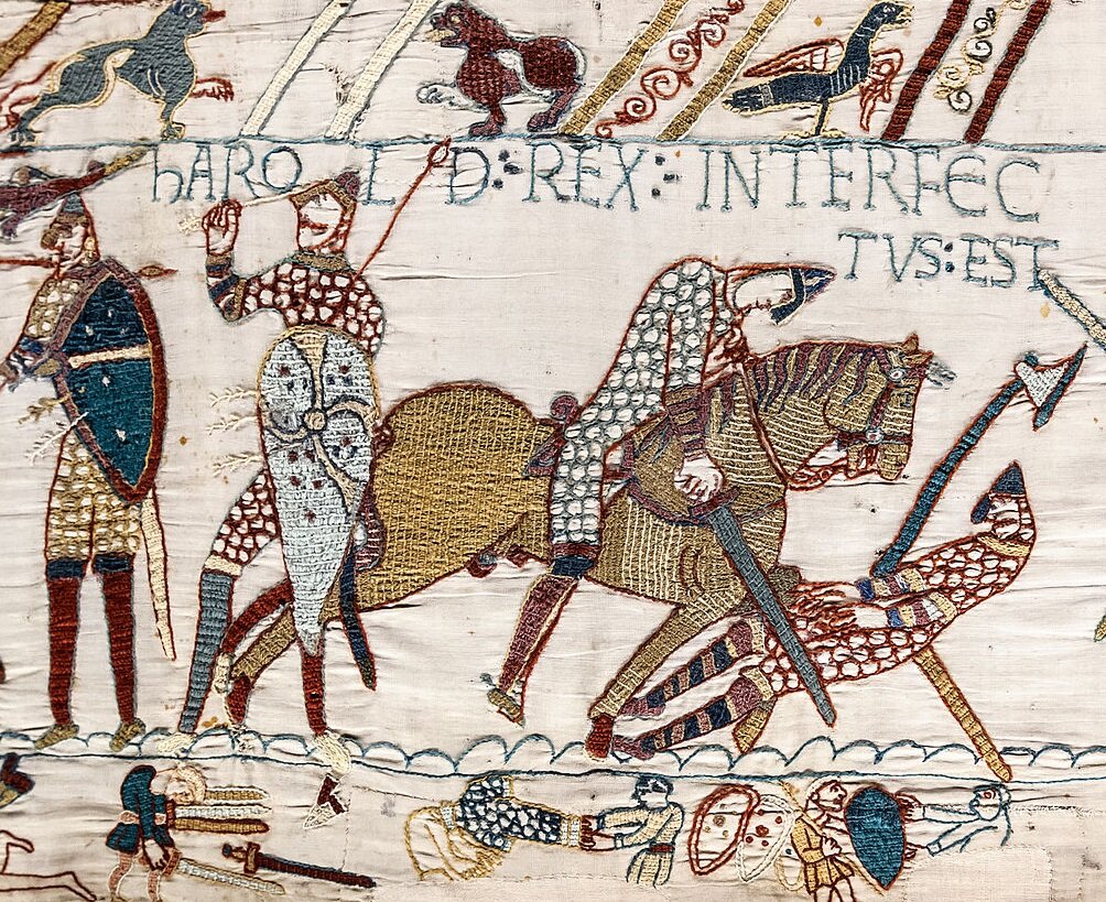 Ilustracja przedstawia walczących żołnierzy. Są uzbrojeni w miecze, tarcze i topory. Jeden z nich jedzie na koniu. Nad i pod nimi znajdują się liczne małe rysunki postaci i zwierząt.