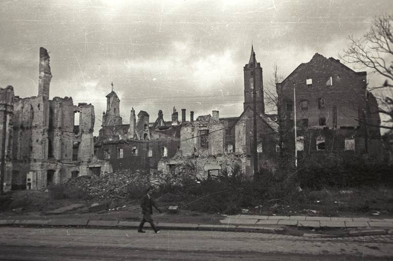 Zdjęcie przedstawia ulicę Wrocławia. Przy niej widać liczne, zbombardowane i zrujnowane budynki mieszkalne.