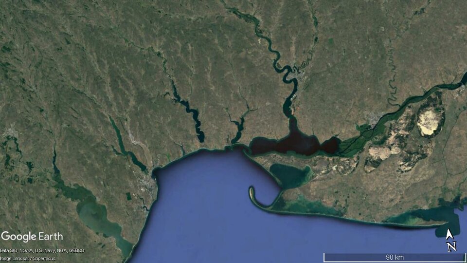 Zdjęcie satelitarne przedstawia wybrzeże limanowe. Ląd zaznaczony jest kolorem zielonym i brunatnym, a woda niebieskim i turkusowym. Od wybrzeża odchodzą długie, kręte linie – zbiorniki wodne powstałe w wyniku odcięcia zatopionych wylotów rzek przez mierzeję utworzoną w wyniku akumulacji materiału naniesionego z rzek w wyniku falowania.