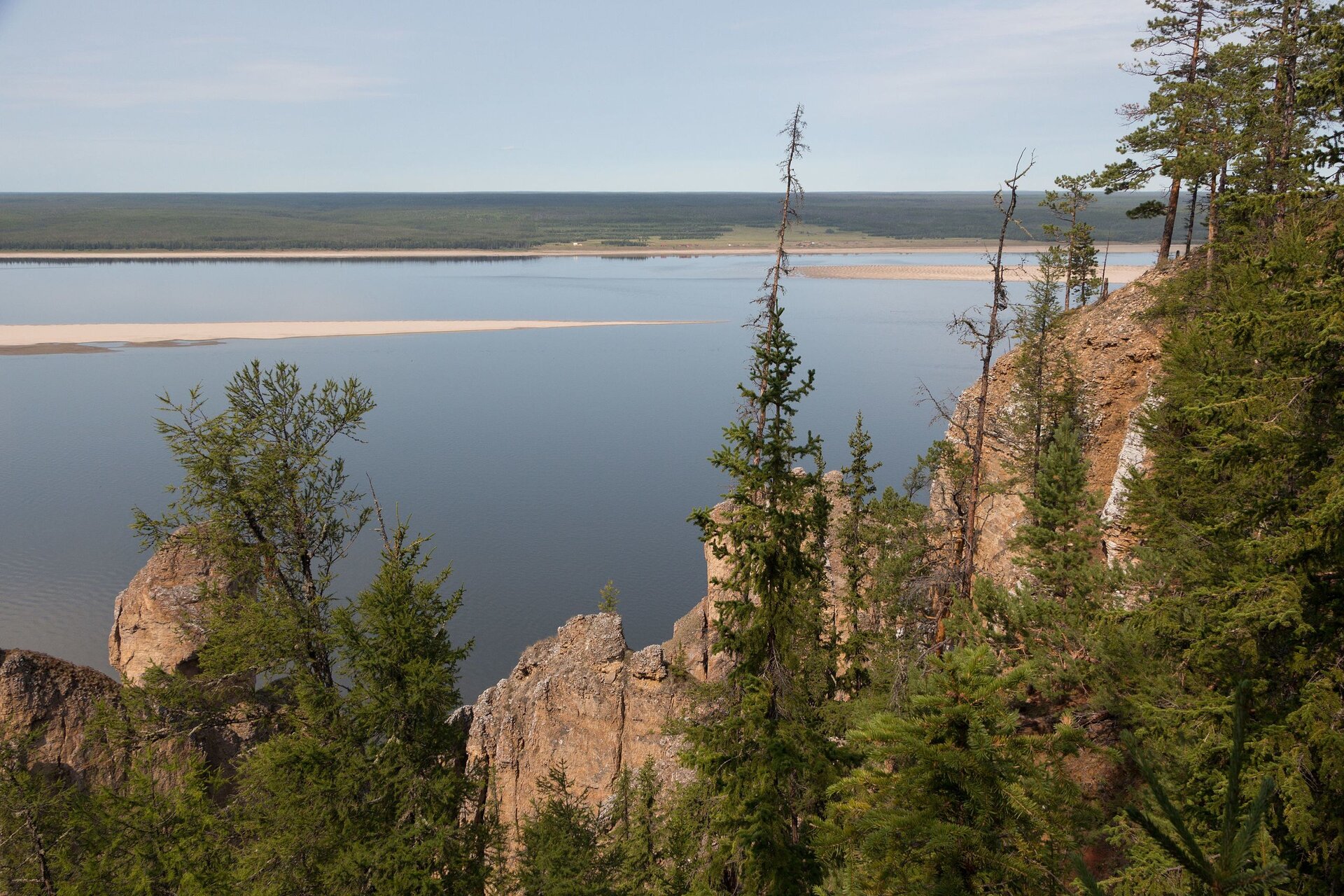 Na zdjęciu zbiornik wodny. Na lewym brzegu są polany. Na prawym brzegu skaliste wzniesienie. 