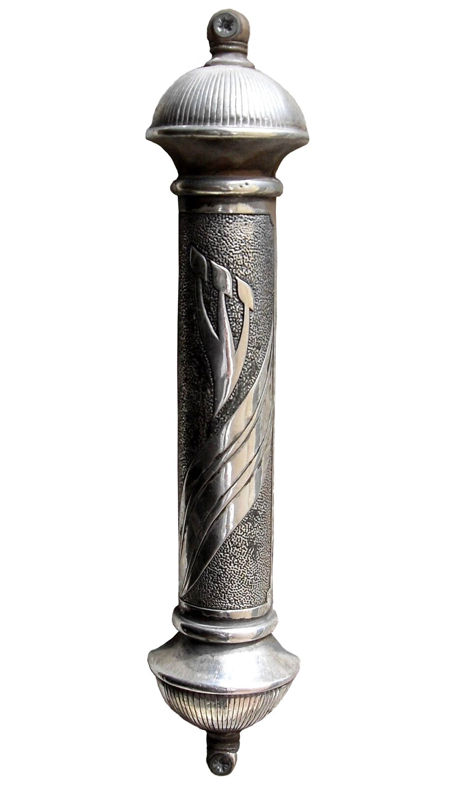 Zdjęcie przedstawia srebrny pojemnik w kształcie walca. Ze zdobioną częścią centralną oraz dwoma prążkowanymi kopułkami na górze i na dole, na ich szczycie umieszczone są śruby, za pomocą których można go przytwierdzić go do futryny.