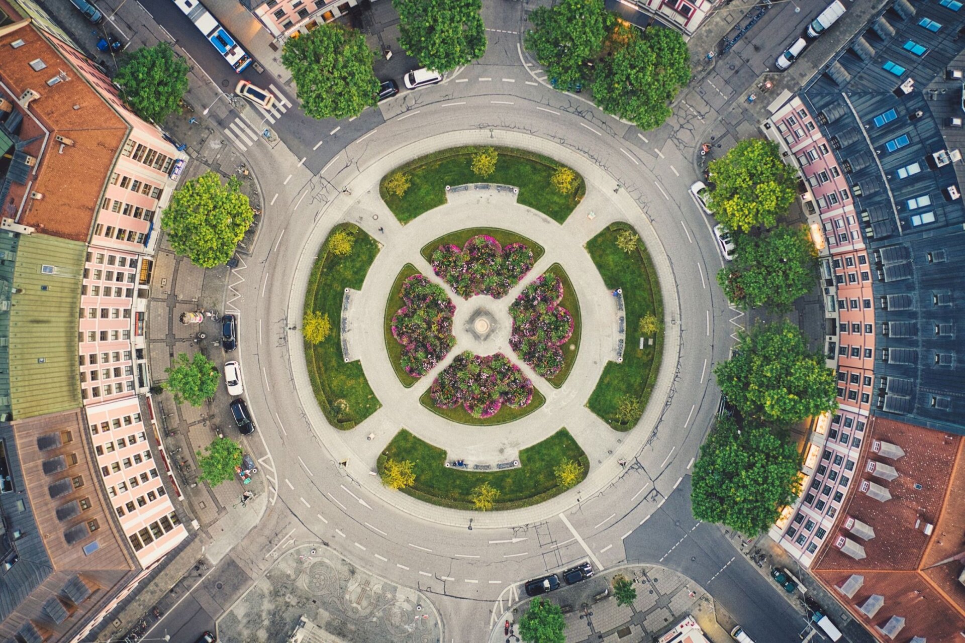  Fotografia wykonana z perspektywy lotu ptaka ukazuje centralny układ przestrzenny fragmentu miasta; centralne miejsce zajmuje rondo i odchodzące od niego ulice. Dalej za pasem zieleni wybudowano domy mieszkalne. Na środku ronda został usytuowany okrągły klomb, dookoła którego ustawiono ławeczki, od jezdni oddziela je pas zieleni. Promieniście w kierunku zabudowań rozchodzą się ulice i chodniki.