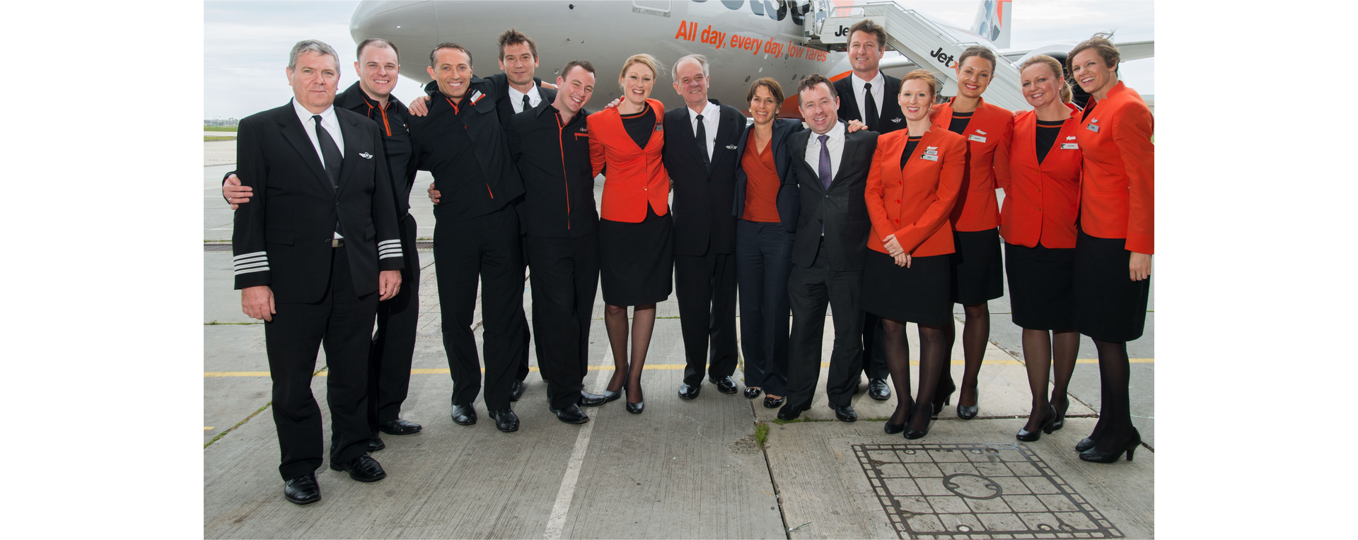 Zdjęcie przedstawia personel samolotu, załogę oraz stewardesy. Personel pozuje do zdjęcia na tle samolotu.