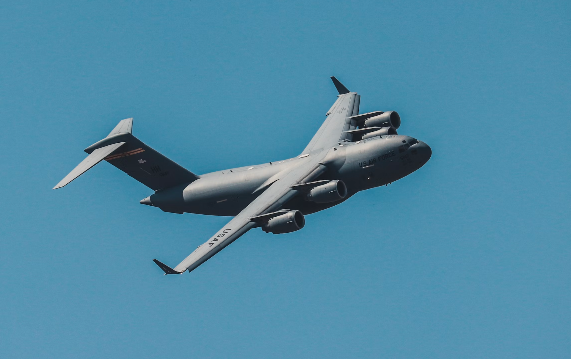 Zdjęcie przedstawia lecący samolot. Samolot widoczny jest od dolnej strony. Widoczne jest jego usterzenie poziome na ogonie oraz skrzydła w połowie długości kadłuba z zamontowanymi pod nimi czterema silnikami.