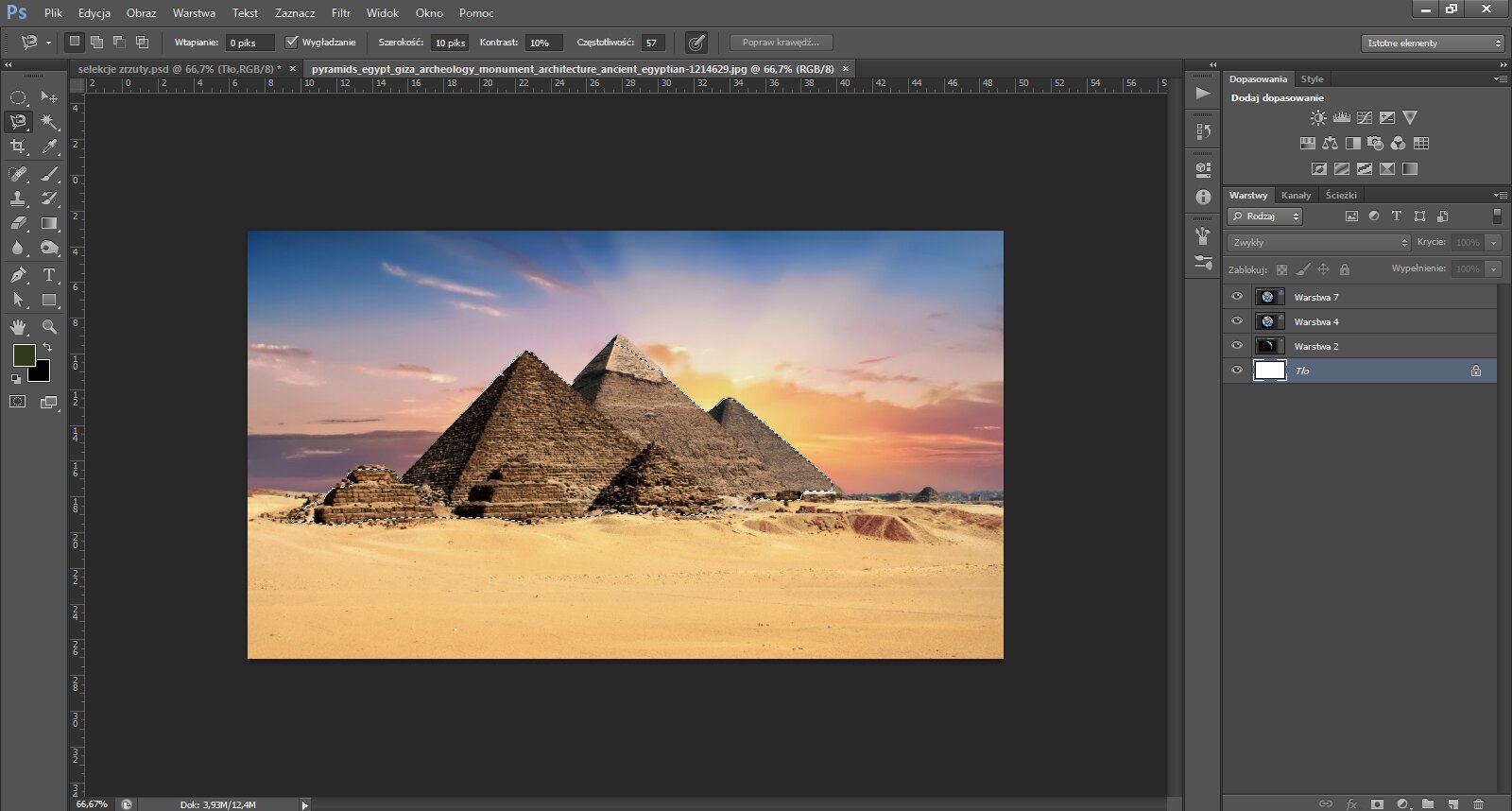 Ilustracja przedstawiając interfejs programu Photoshop. W obszarze roboczym znajduje się fotografia piramid tle zachodzące słońca. Piramidy zaznaczono za pomocą narzędzia Lasso. 