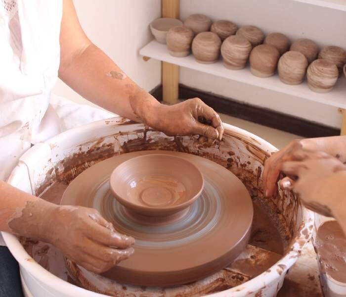 Wytwarzanie wyrobu ceramicznego. Drugie zdjęcie przedstawia gotowe naczynie na kole garncarskim.