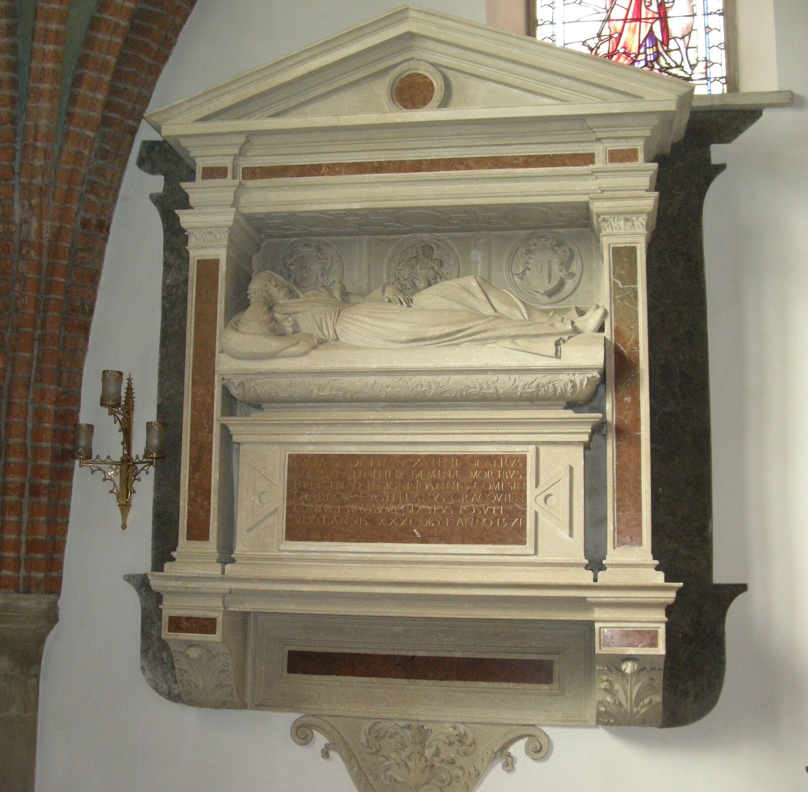 Ilustracja o kształcie kwadratu  przedstawia fotografię nagrobka Barbary Tarnowskiej autorstwa Bartolomea Berrecciego. Postać leży w pozycji na wznak na łożu. Nagrobek osadzony jest w prostokątnej niszy, dekorowanej po bokach pilastrami. Ściana nagrobka zwieńczona jest trójkątnym tympanonem. Obok na ścianie wisi świecznik a po lewej widoczny jest fragment służek sklepienia. Nad nagrobkiem znajduje się fragment witrażowego okna. 