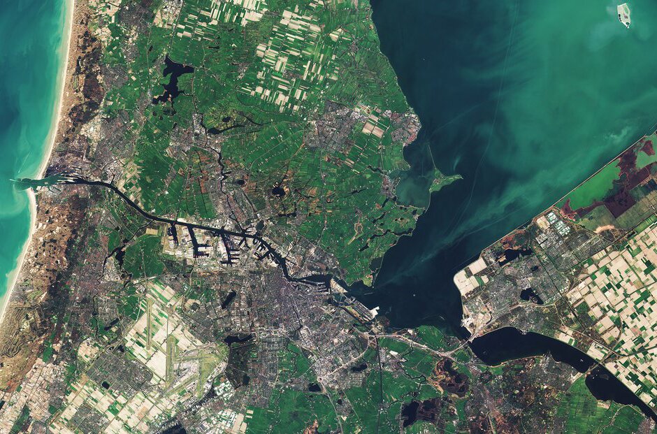 Fotografia barwna przedstawiająca zdjęcie satelitarne Amsterdamu wraz z rzekami