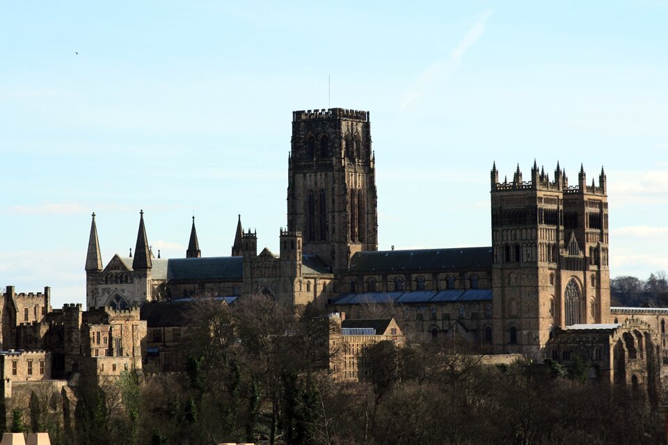 Ilustracja o kształcie poziomego prostokąta przedstawia fotografię Katedry Chrystusa, Błogosławionej Marii Panny i Świętego Kutberta w Durham w Anglii. Cały budynek przedstawiony jest na tle błękitnego nieba, od przodu zasłonięty częściowo drzewami. Zdjęcie prezentuje kościół od strony północno‑zachodniej. Widoczny jest fragment ściany z portalem głównym i wieżami, zachodnie ściany nawy bocznej i głównej, fragment transeptu zachodniego oraz wieża znajdująca się na skrzyżowaniu naw.