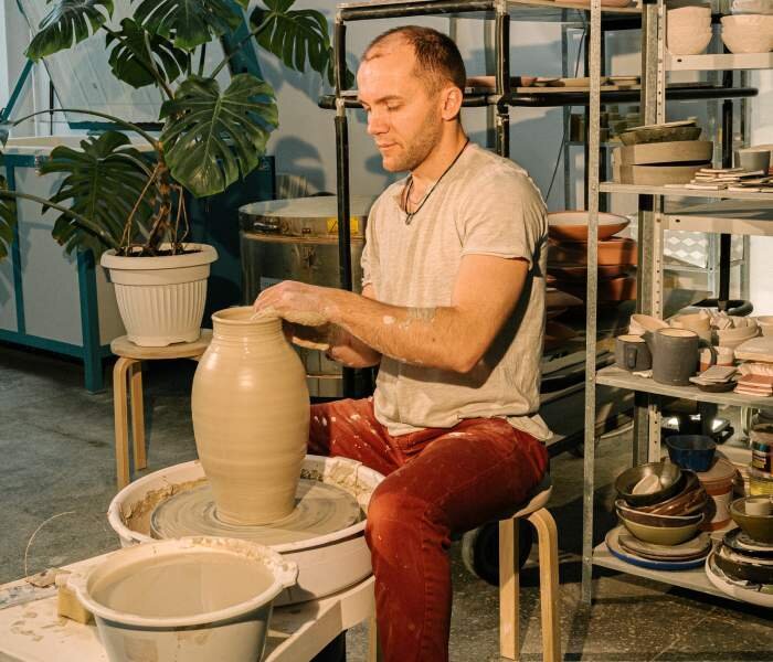 Gotowy do wstępnego wypalania wyrób ceramiczny. Trzecie zdjęcie przedstawia mężczyznę siedzącego przy kole garncarskim na który stoi gotowy wazon.
