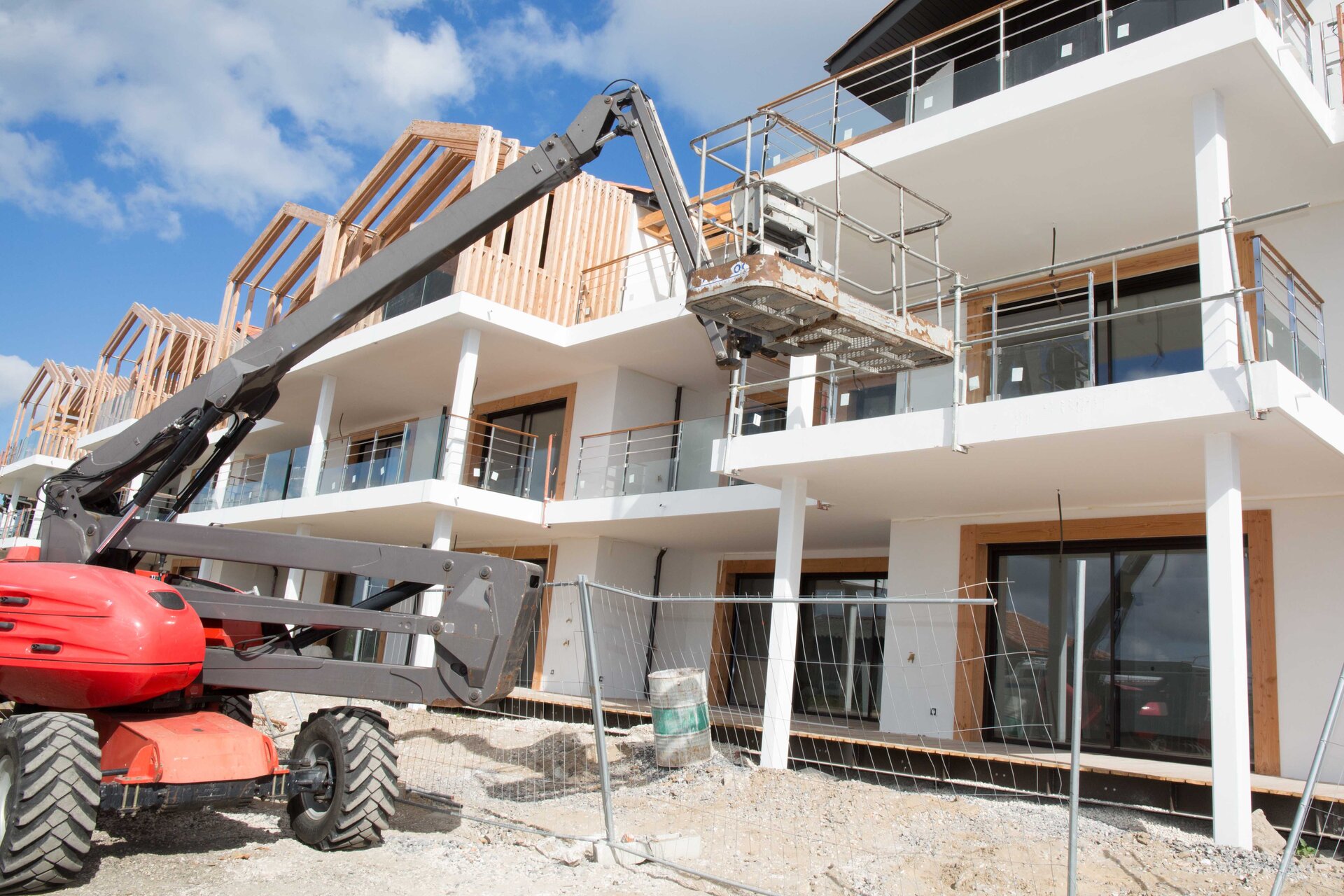 Wyciąg budowlany.Zdjęcie przedstawia pojazd z segmentowym ramieniem, które spełnia funkcję wysięgnika. Na wysięgniku znajduje się platforma otoczona barierkami dla bezpieczeństwa pracownika. 