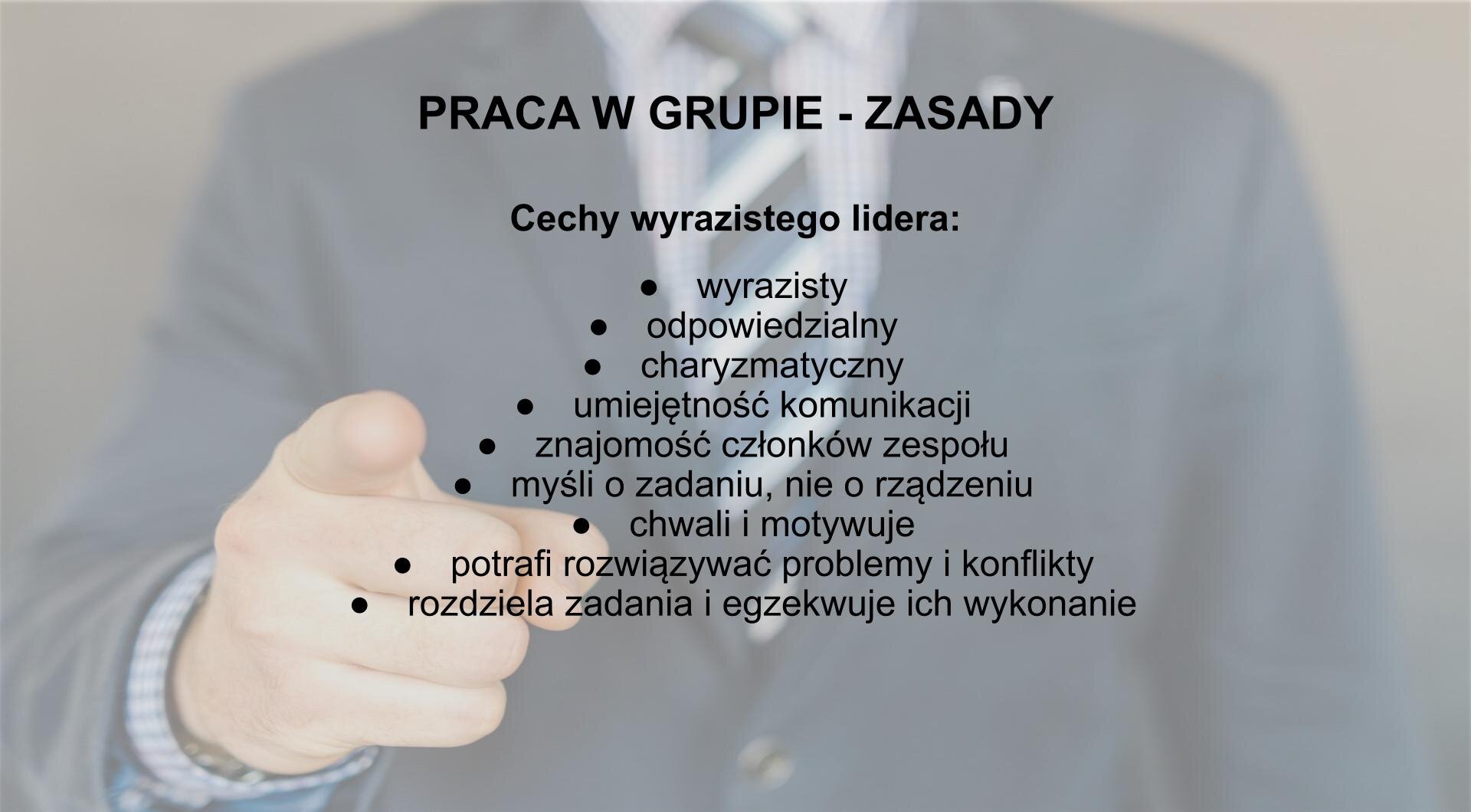 Slajd zatytułowany: "Praca w grupie - zasady". Niżej tekst: Cechy wyrazistego lidera: wyrazisty; odpowiedzialny; charyzmatyczny; umiejętność komunikacji; znajomość członków zespołu; myśli o zadaniu, nie o rządzeniu; chwali i motywuje; potrafi rozwiązywać problemy i konflikty; rozdziela zadania i egzekwuje ich wykonanie. W tle rozjaśnione zdjęcie klatki piersiowej mężczyzny ubranego w koszulę, krawat i marynarkę, z wyciągniętą prawą ręką i wysuniętym palcem wskazującym w kierunku aparatu. 