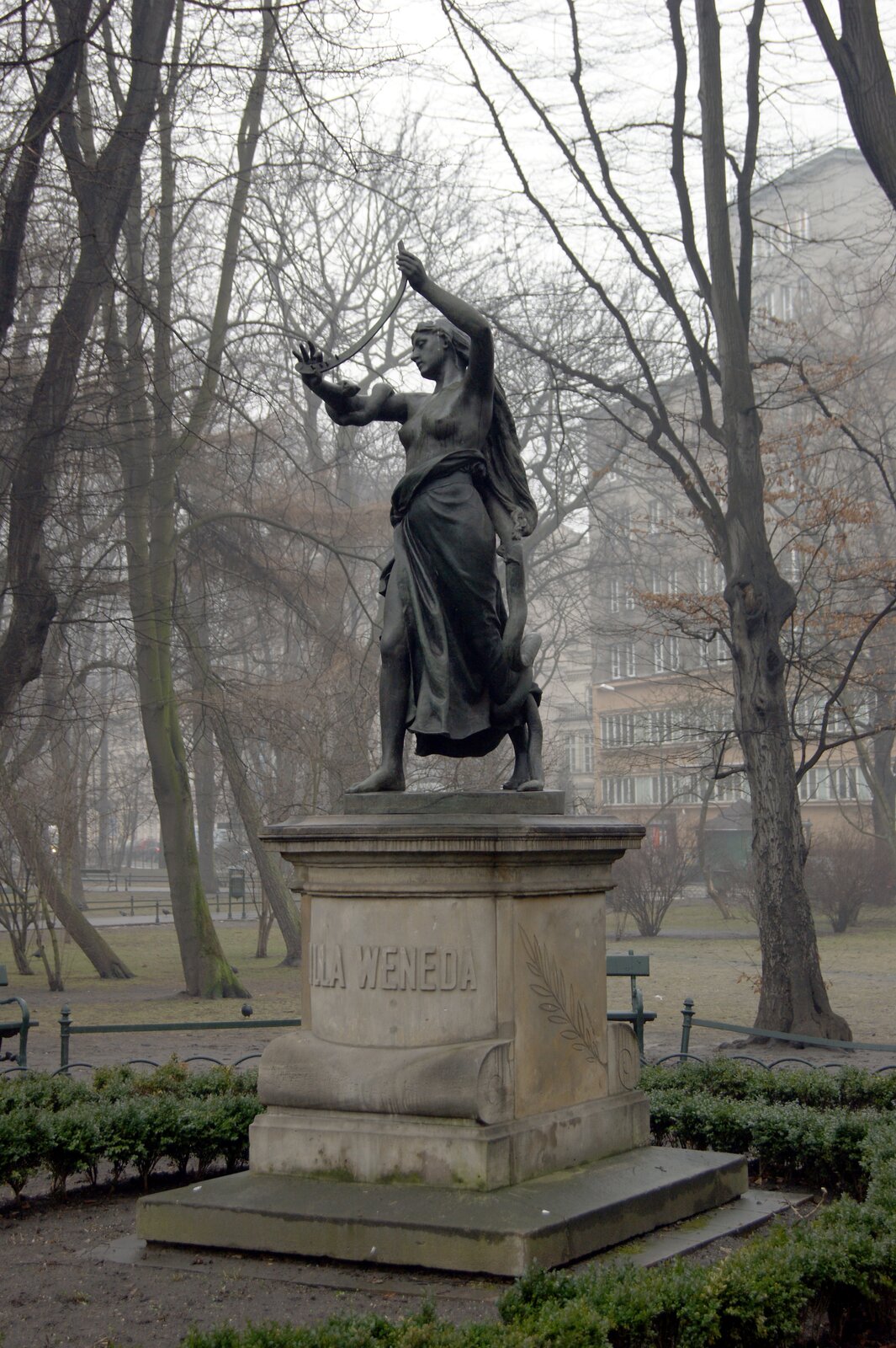 Zdjęcie przedstawia pomnik. Na cokole stoi kobieta z obnażonymi piersiami. Jej ciało owinięte jest przez długiego węża.