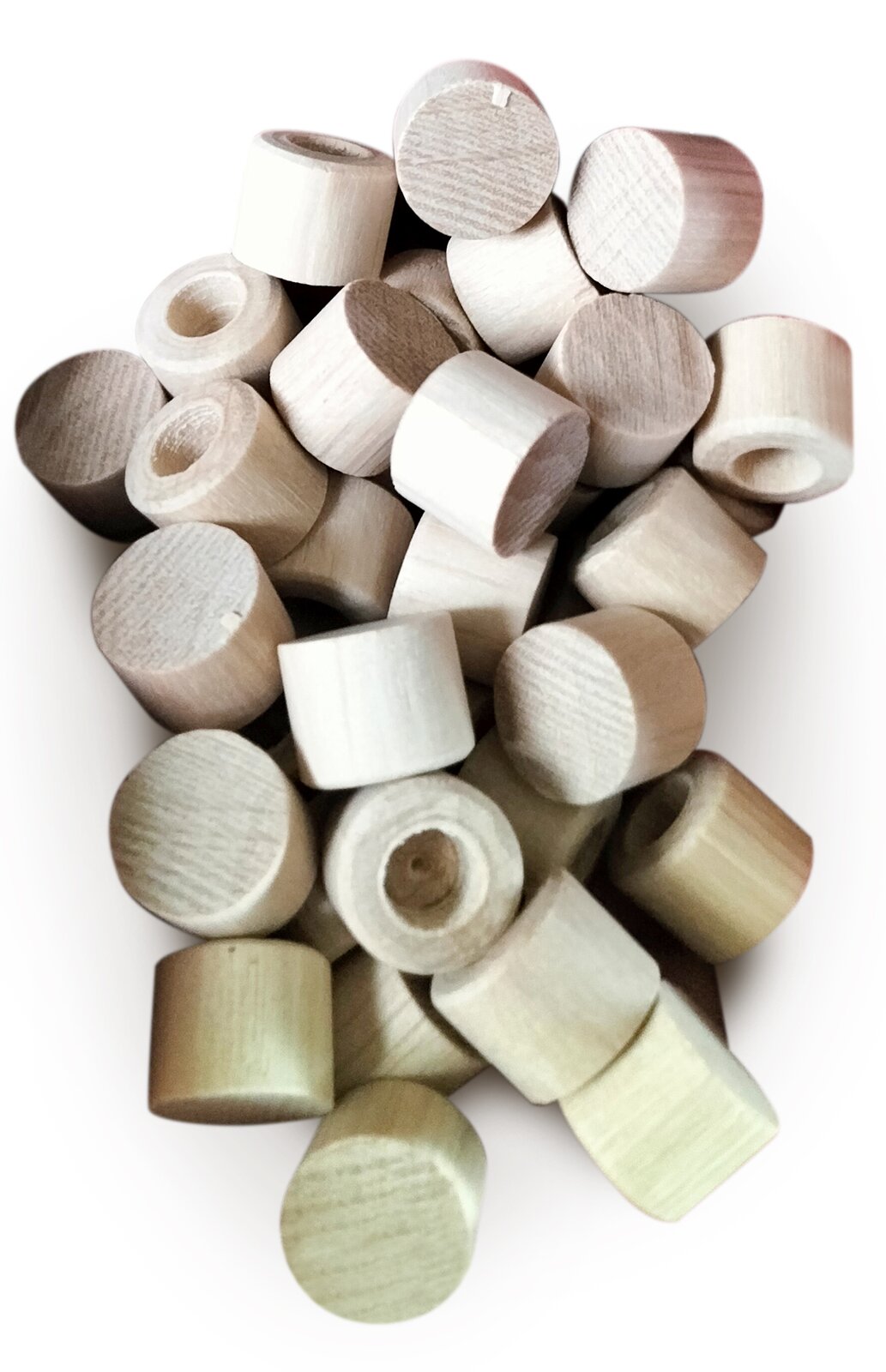 Zdjęcie przedstawia dyble grabowe stosowane do otworów w ramach żeliwnych pod kołki stroikowe. Widoczne są krótkie cylindryczne dyble z jasnobeżowego drewna z niewielkim okrągłym zagłębieniem pośrodku. Dyble są położone na siebie w nieuporządkowany sposób.