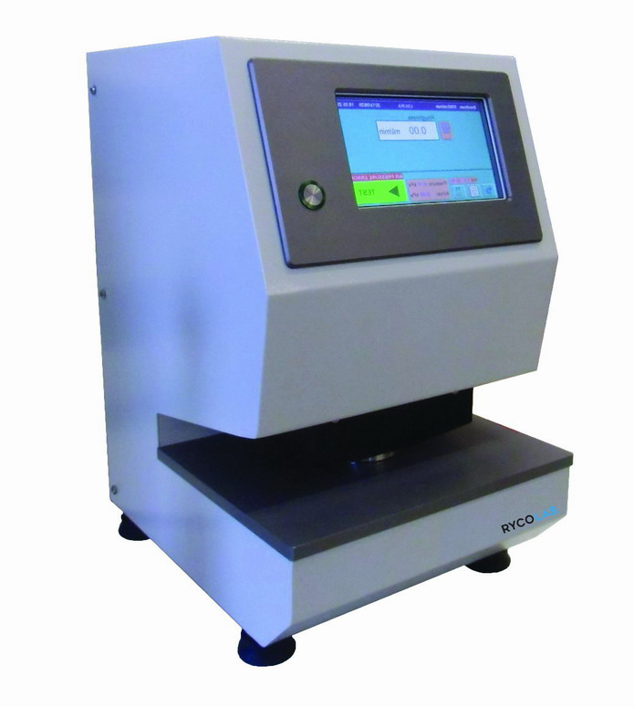 Zdjęcie przedstawia aparat Bekka. Urządzenie, wyposażone w antypoślizgowe nóżki, składa się z panelu z wyświetlaczem oraz blatu umieszczonych w masywnej obudowie.