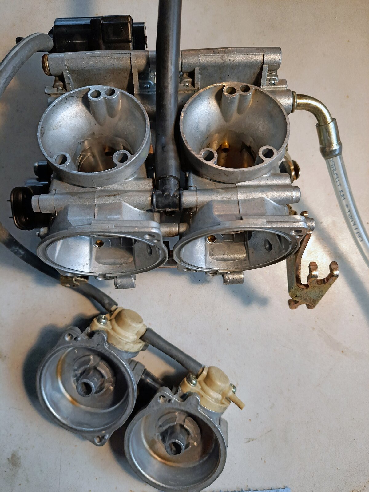 Na ekranie przedstawiono zestaw dwóch gaźników z wymontowanymi membranami przepustnic podciśnieniowych.