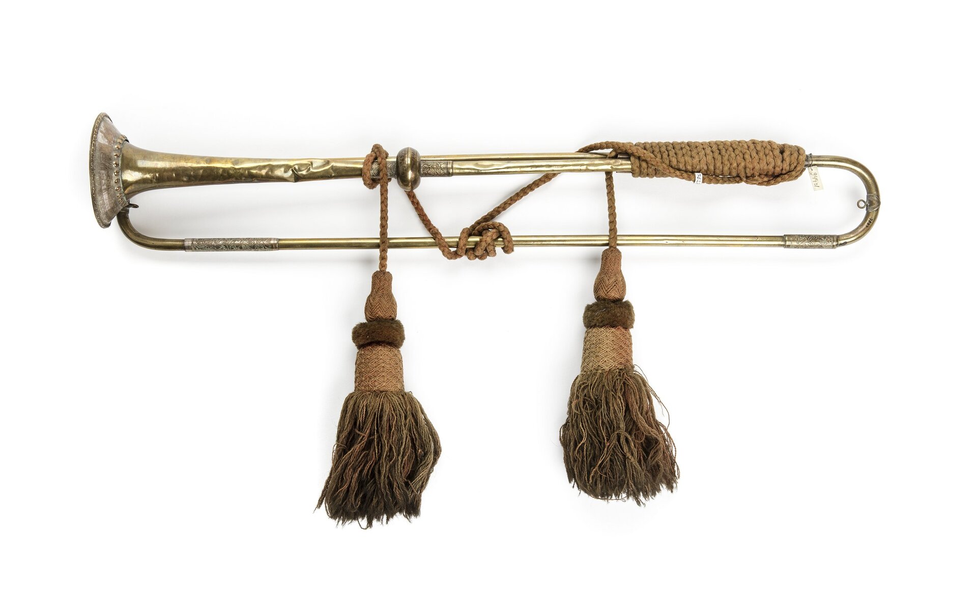 Zdjęcie przedstawia złotą trąbkę z XVII wieku. Jej część owinięta jest sznurkiem zakończonym chwostami.