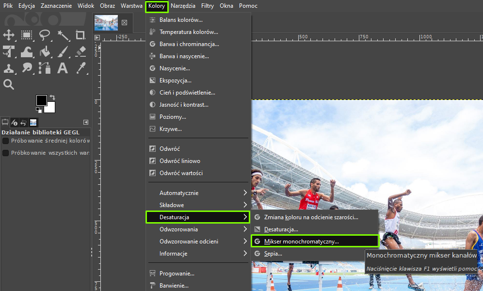 Ilustracja przedstawia okno programu. Z menu wybrano opcję Kolory, a następnie Desaturację, a w niej: Mikser monochromatyczny. Obok informacja: Monochromatyczny mikser kanałów. Po lewej stronie jest panel dotyczący Działania biblioteki GEGL. W obszarze roboczym jest kolorowe zdjęcie zawodników, podczas biegu na stadionie.  