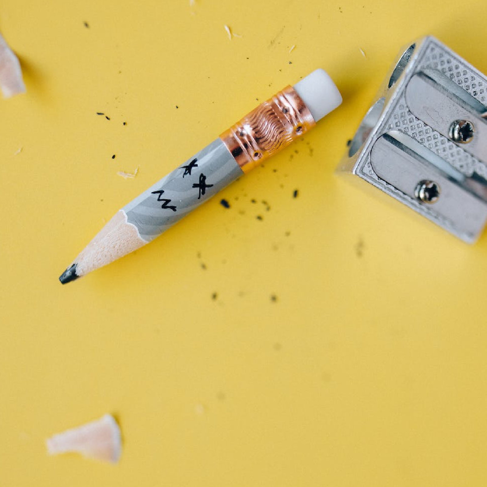 Ilustracja przedstawia kończący się ołówek i gumkę na jego drugiej stronie. Obok leży temperówka. 