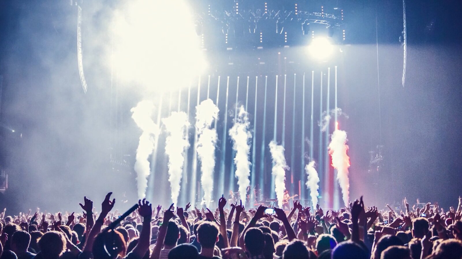   Hast du bereits deutsche Musik gehört? Wenn nicht, dann ist nun der beste Moment, es zu versuchen. Konzentriere dich nicht nur auf Melodie und Beat, sondern vor allem auf den Text. Falls du etwas nicht verstehst, schau die Lyrics online nach und übersetze sie. So kannst du das Lied beim nächsten Hören mitsingen und dein neu erlerntes Vokabular üben. So einfach lässt sich das Lernen mit Spaß verbinden.
5. Deutsche Songs hören
Hast du bereits deutsche Musik gehört? Wenn nicht, dann ist nun der beste Moment, es zu versuchen. Konzentriere dich nicht nur auf Melodie und Beat, sondern vor allem auf den Text. Falls du etwas nicht verstehst, schau die Lyrics online nach und übersetze sie. So kannst du das Lied beim nächsten Hören mitsingen und dein neu erlerntes Vokabular üben.
 Opis: Ilustracja ukazuje energetyczną scenę podczas koncertu, gdzie migoczą światła laserów i unosi się słupy dymu. Na widowni widoczne są tłumy młodych ludzi, podnoszących ręce w ekscytacji.
