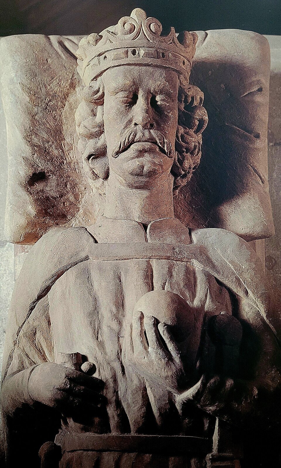 Ilustracja przedstawia płaskorzeźbę Władysława Łokietka. Na głowie ma koronę. Jego włosy są krótkie i kręcone. Posiada wąsy. Ręce ma złożone na piersi. U pasa ma miecz. Znajduje się w pozycji leżącej, głowa jest położona na poduszce.