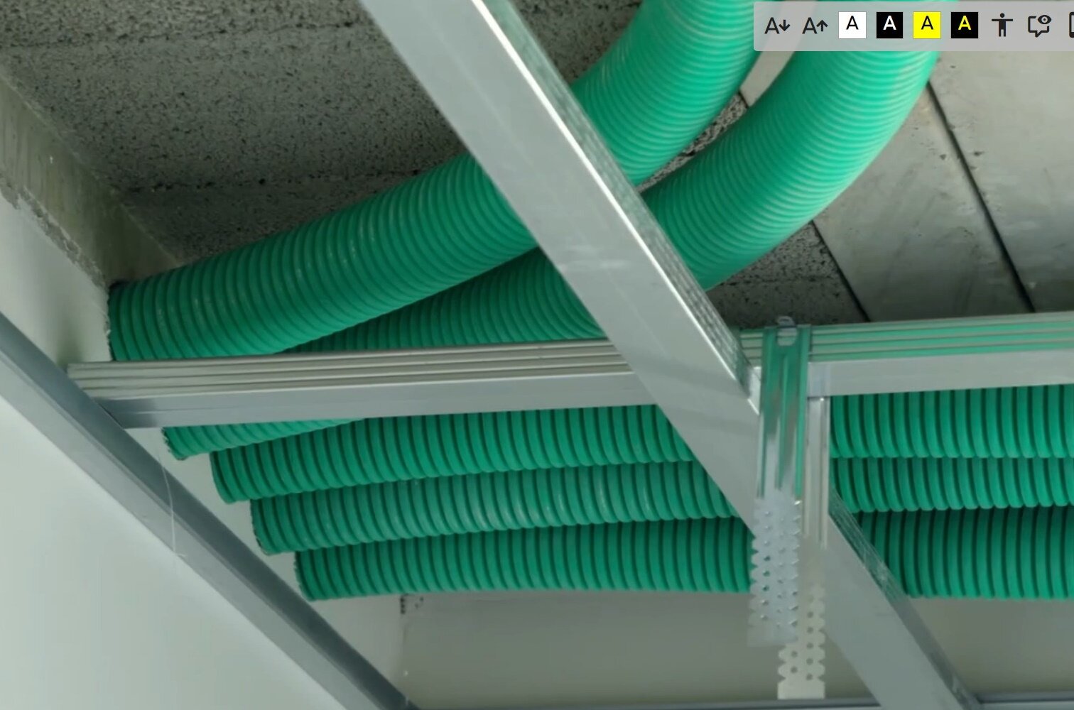 Zdjęcie przedstawia przewody wentylacyjne zamontowane pod sufitem podwieszanym. Przewody składają się dużych, zielonych rur.
Opisy prezentowanych na grafikach obiektów są załączone w treści.