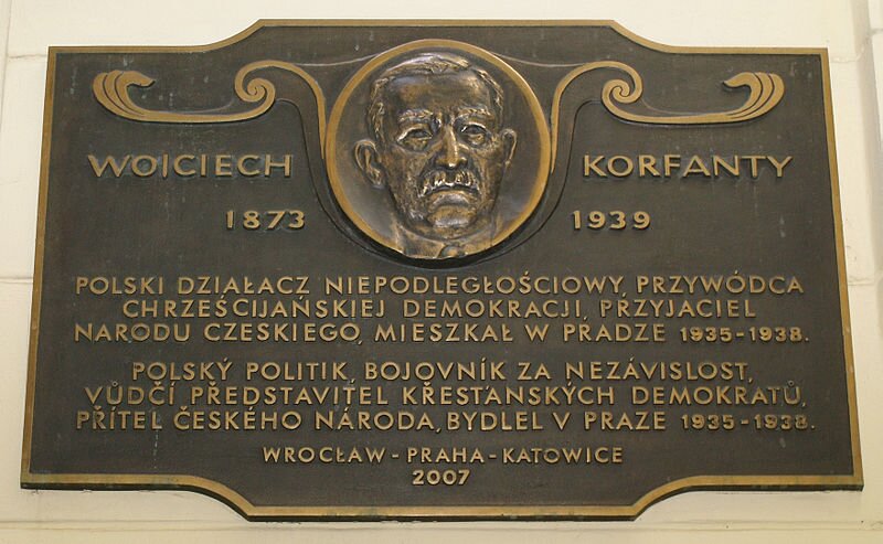 Zdjęcie przedstawia miedzianą tablicę pamiątkową ku czci Wojciecha Korfantego wiszącą na ścianie budynku w Pradze. W jej górnej znajduje się podobizna Korfantego i napis Wojciech Korfanty. 1873–1939. Poniżej treść: "Polski działacz niepodległościowy. Przywódca chrześcijańskiej demokracji, przyjaciel narodu czeskiego, mieszkał w Pradze 1935–1938”. Niżej jest to samo w języku czeskim. U dołu napis: „Wrocław–Praha–Katowice 2007”