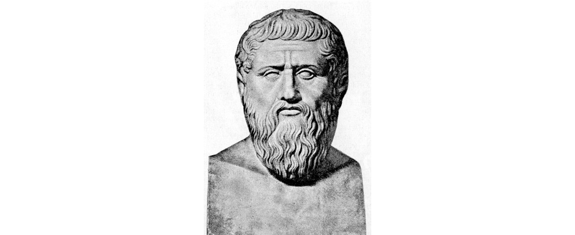 Ilustracja przedstawia fragment rzeźby mężczyzny w średnim wieku. Ukazany jest od klatki piersiowej w górę. Mężczyzna ma długie włosy, brodę i wąsy. Nie posiada ubrania.