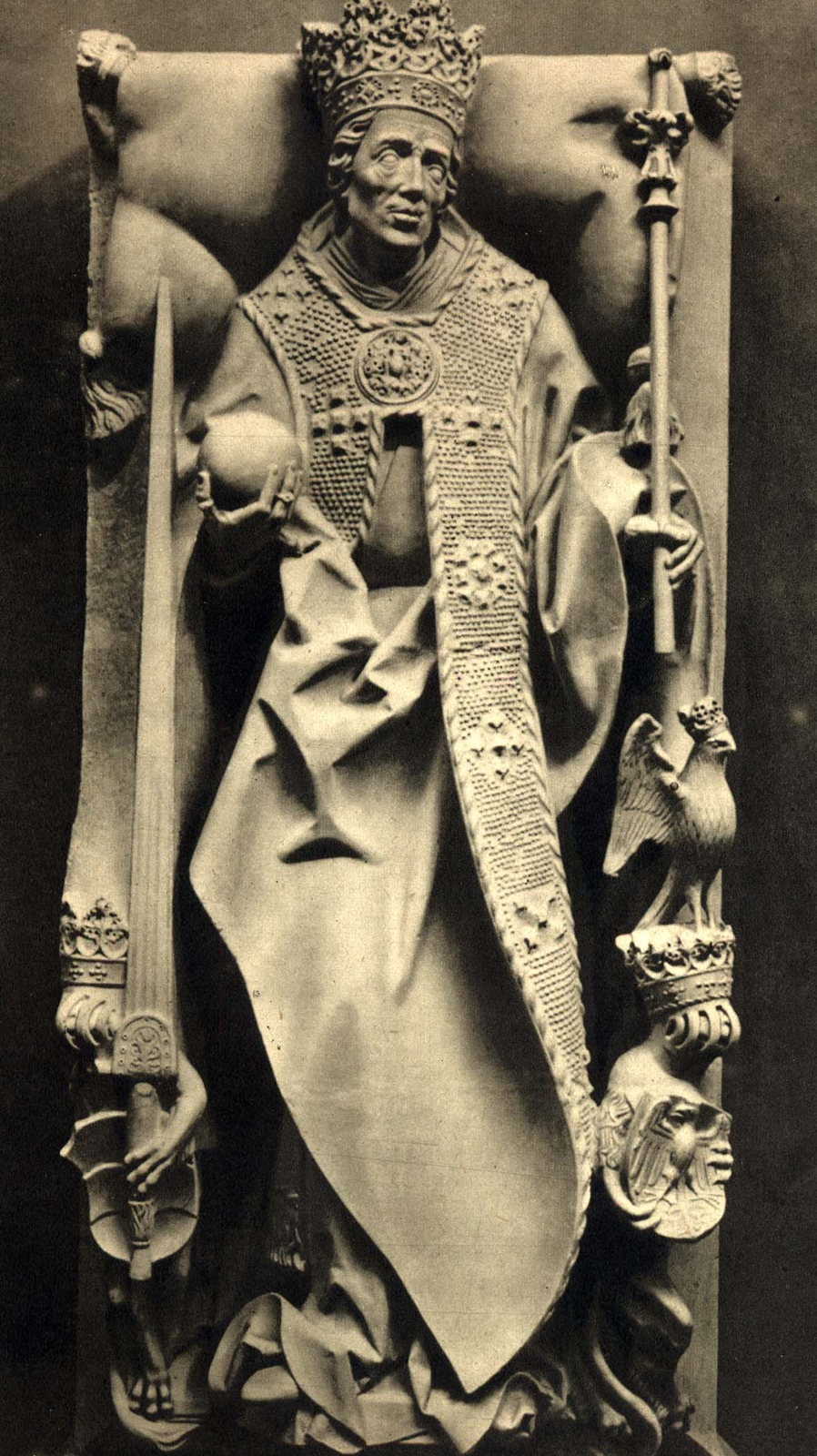 Nagrobek Kazimierza Jagiellończyka w Katedrze Wawelskiej. Figura mężczyzny odzianego w długie szaty królewskie z koroną na głowie. W prawej dłoni trzyma miecz, w lewej buławę.