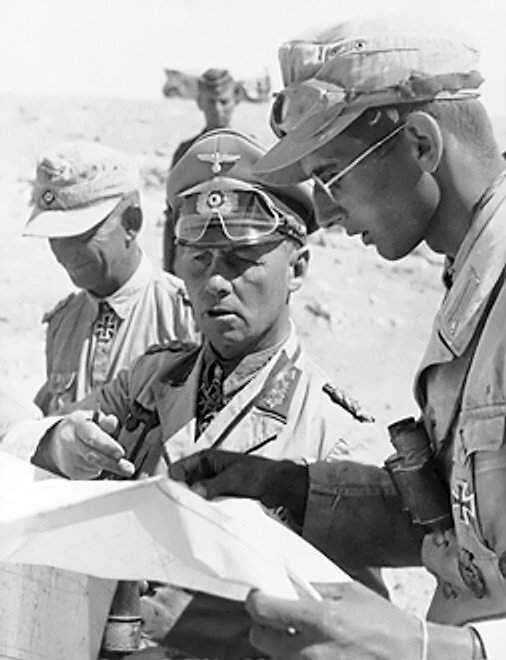 Zdjęcie przedstawia niemieckiego oficera i żołnierza. Studiują mapę. W tle dwóch innych żołnierzy i piasek pustyni.